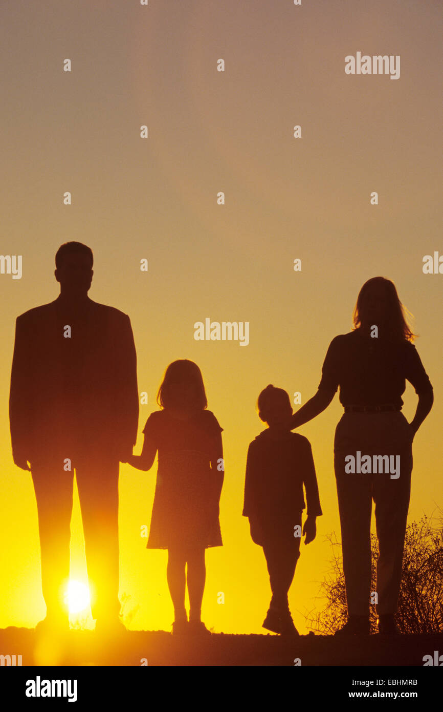 Familie in der Silhouette bei Sonnenuntergang Stockfoto