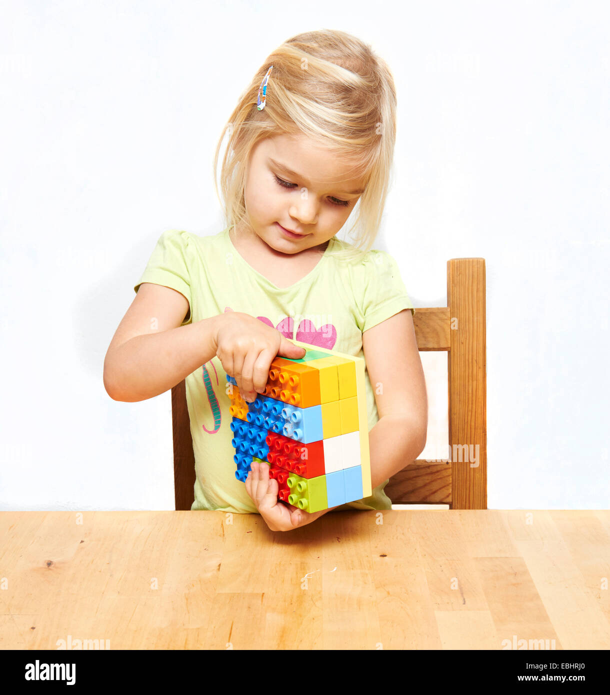 Porträt von kleinen Kind blondes Mädchen spielen mit Kunststoff Bausteine, weißer Hintergrund Stockfoto