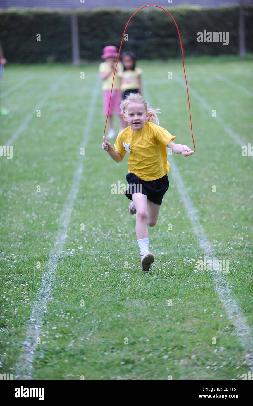 Kind, springen und laufen am Sporttag Stockfoto