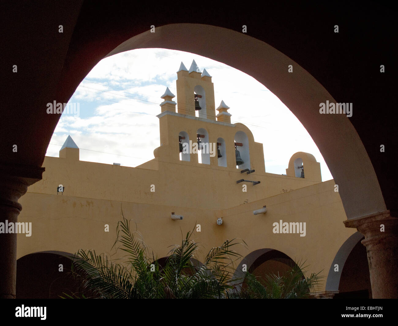 Iglesia de San Roque Church Glocken aus betrachtet die unter einem Bogen im Hof des Kulturinstituts, Campeche, Mexiko Stockfoto
