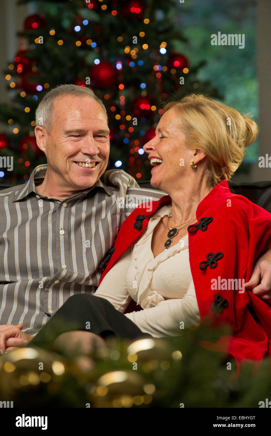 Applying paar saß durch eine Lockerung der Weihnachtsbaum Stockfoto