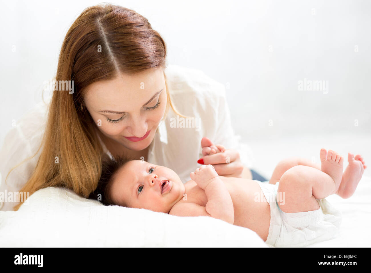 Glückliche Mutter neugeborenes Baby Hand hält Stockfoto