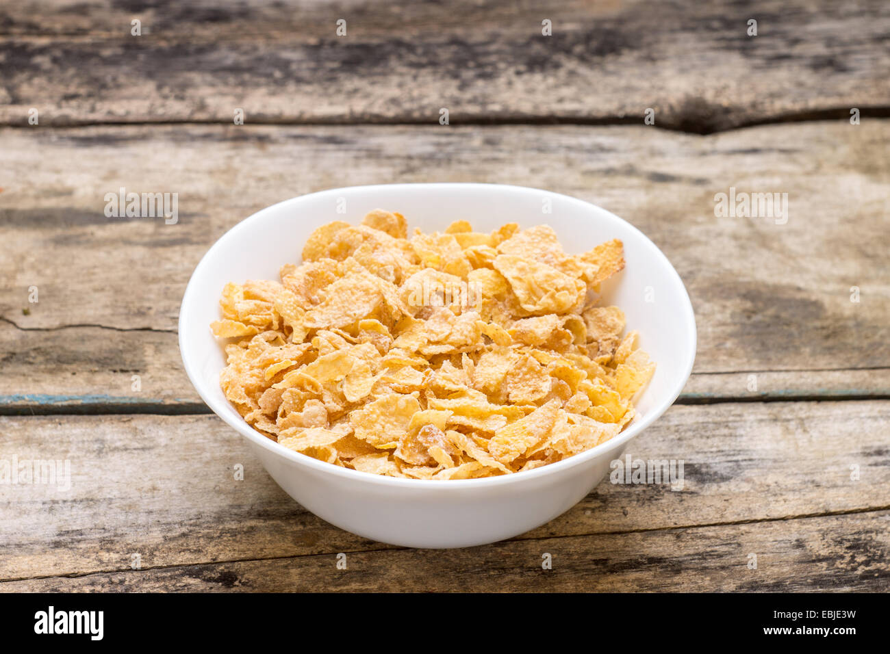 Corn Flakes in weißer Schale auf Holz Hintergrund. Gesunde Energie ood Stockfoto