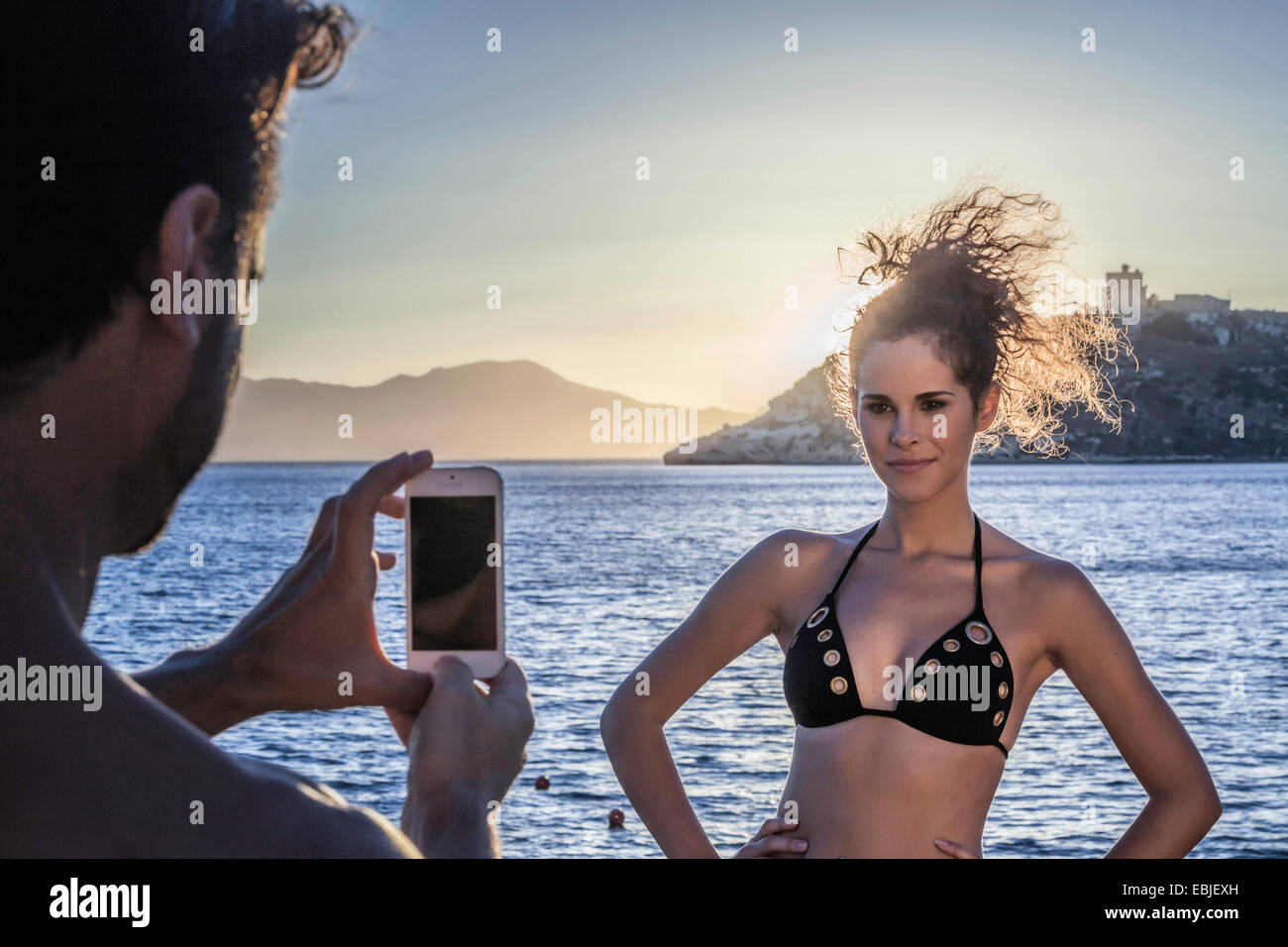 Mann fotografiert junge Frau im Urlaub Stockfoto