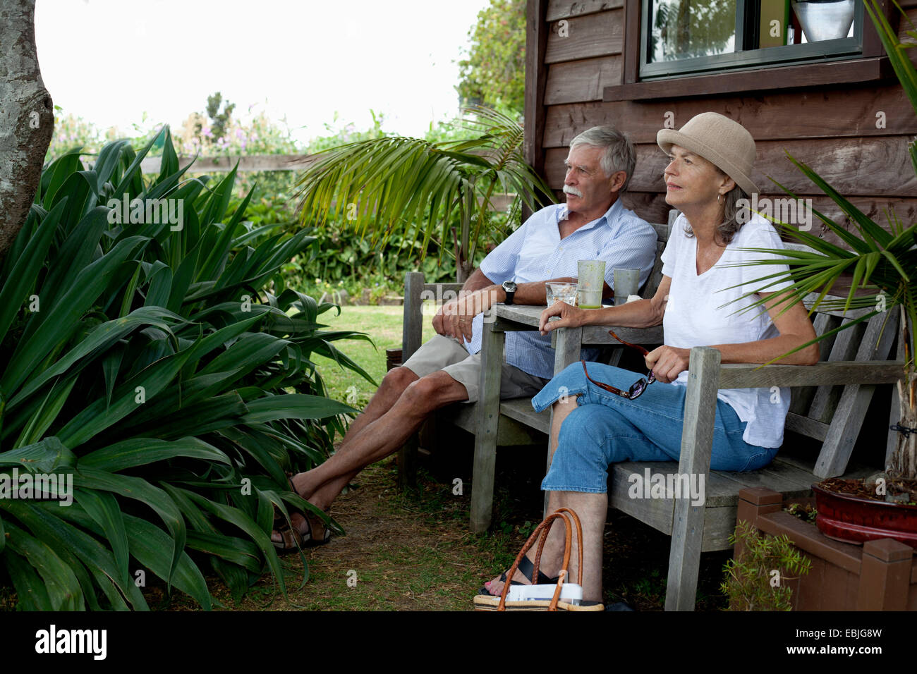Älteres paar entspannende von Holzhütte, Raglan, Neuseeland Stockfoto