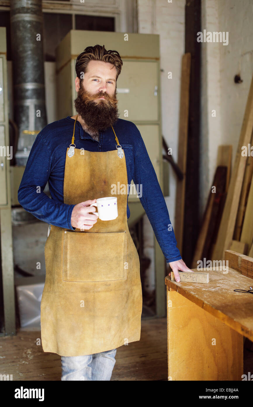 Porträt von Mitte adult Handwerker Kaffeetrinken in Orgelwerkstatt Stockfoto
