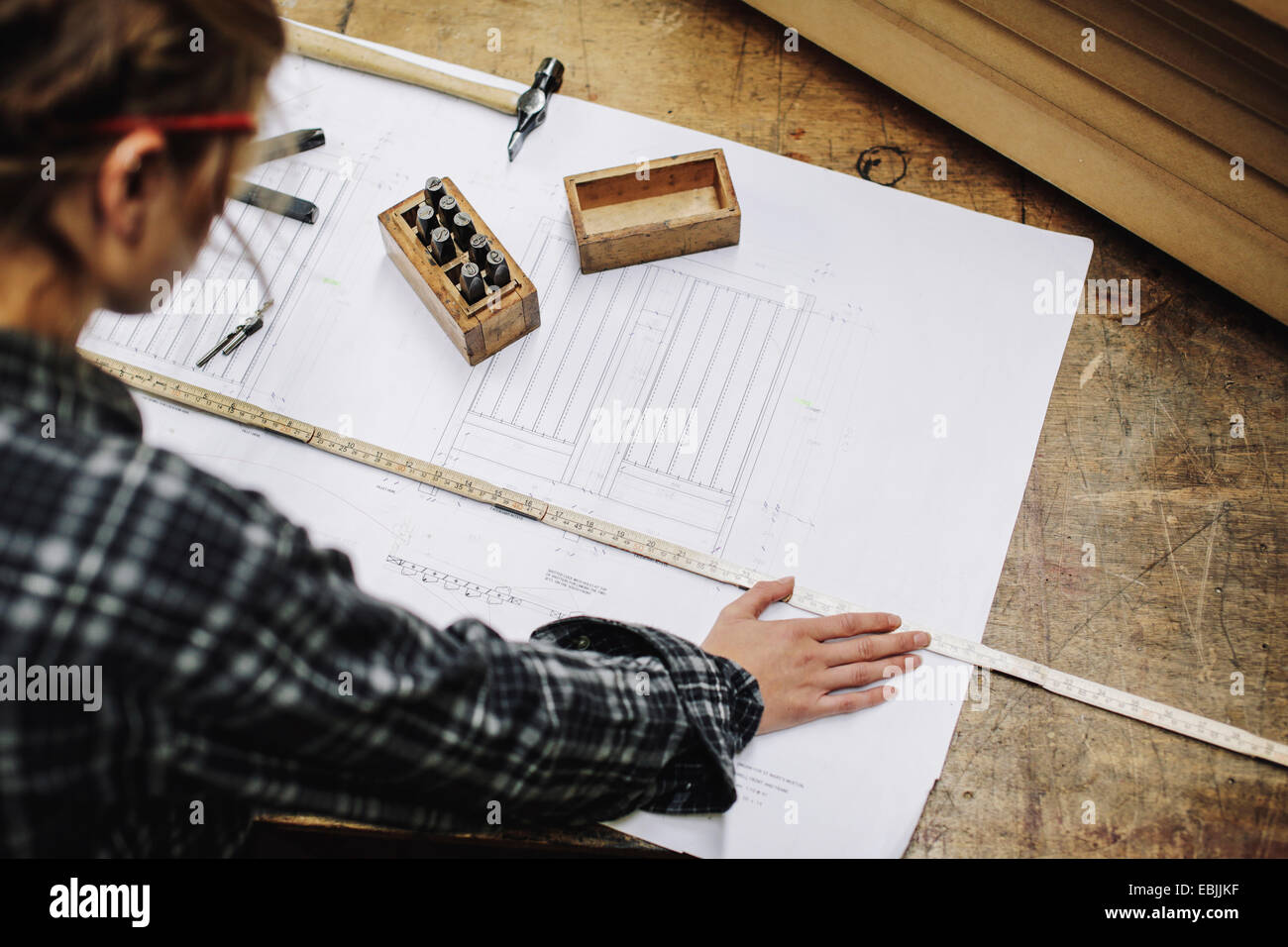 Junge Handwerkerin Blaupause im Rohr Orgelwerkstatt messen Stockfoto