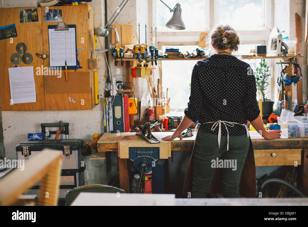 Rückansicht des junge Handwerkerin an Werkbank in Orgel-workshop Stockfoto Rückansicht des junge Handwerkerin an Werkbank in Orgel-workshop Stockfoto