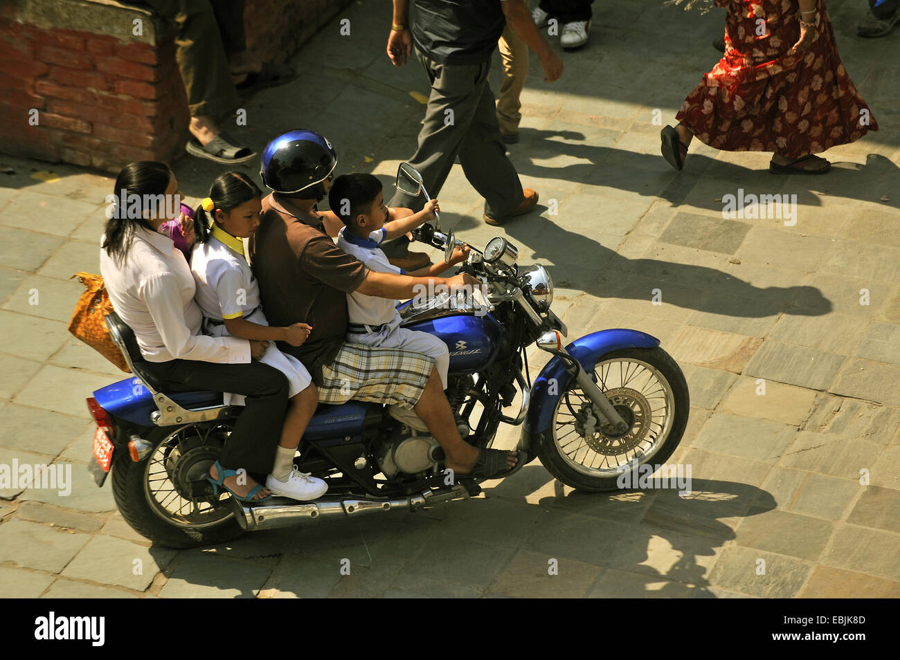 Familie mit zwei Kindern, die Überquerung der Durbar Square zusammen auf einem Motorrad, Nepal, Kathmandu Stockfoto