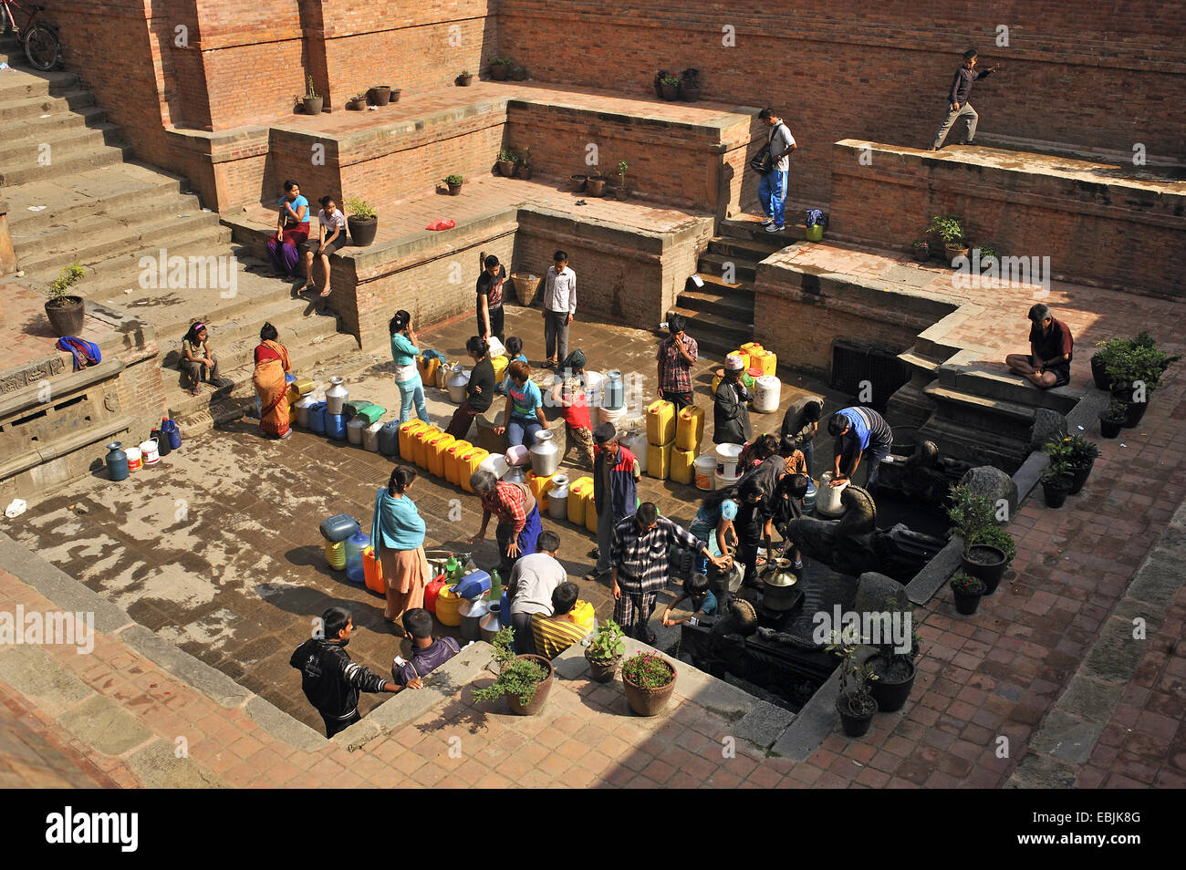 eine Menge Leute, die Wasser an einem Punkt der öffentlichen Wasserversorgung in der Stadt, Nepal, Patan Stockfoto
