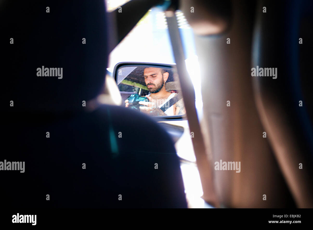 Reflexion der junge Mann im Auto Außenspiegel Stockfoto