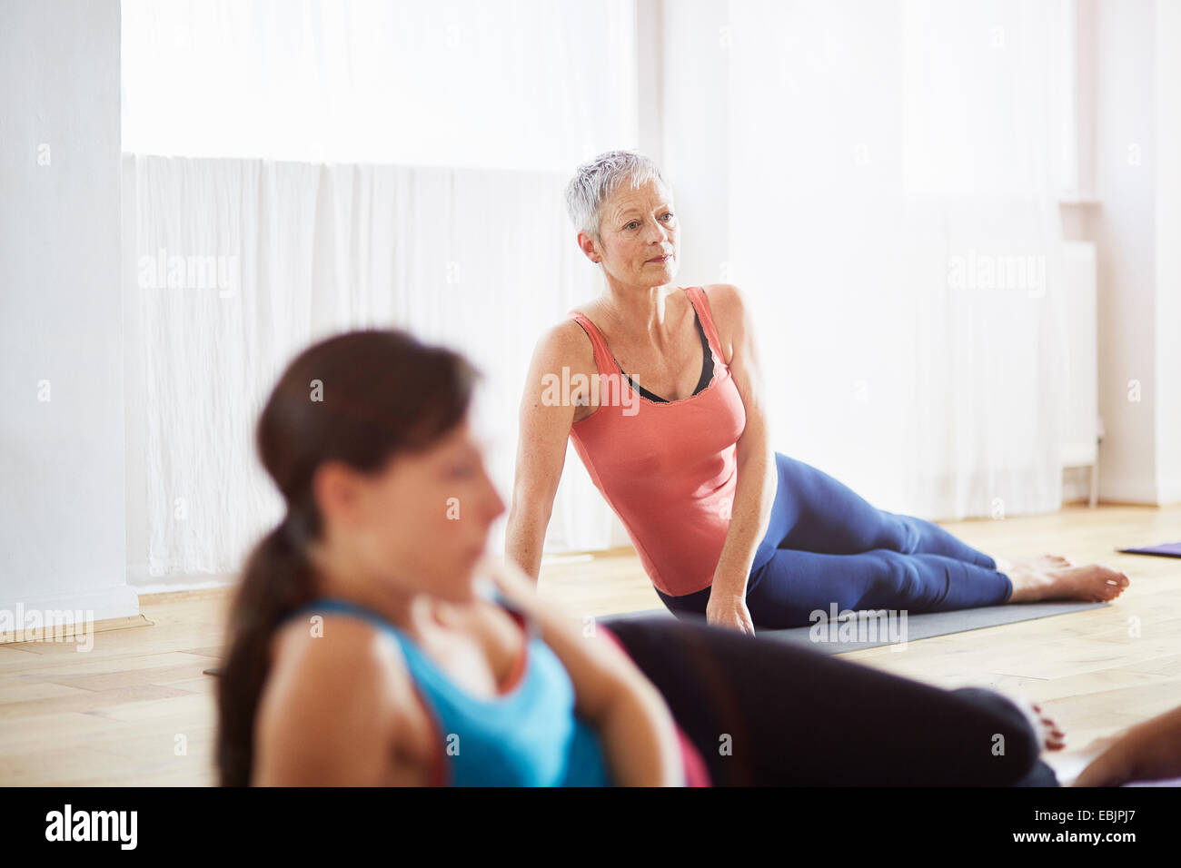 Zwei Frauen liegen auf der Seite in Pilates-Klasse Stockfoto