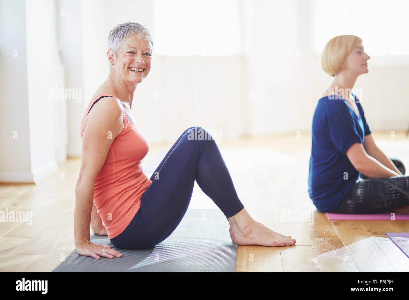 Porträt von Reife Frau sitzen auf Boden in Pilates-Klasse Stockfoto