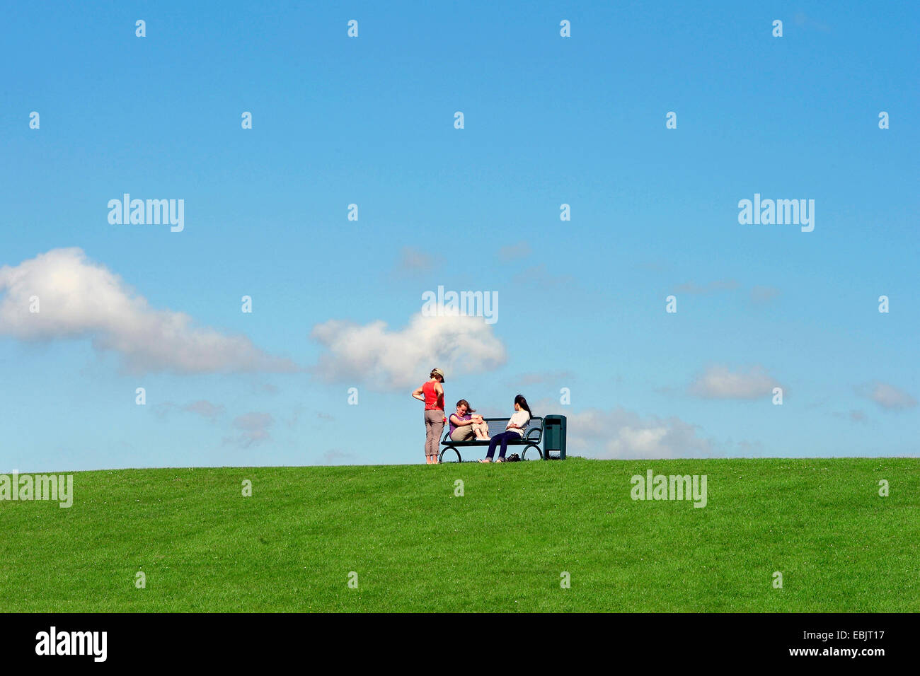 drei Frauen sitzen auf einer Bank auf dem Deich der Nordsee, Deutschland, Sachsen, Cuxhaven, Dorum-Neufeld zu senken Stockfoto