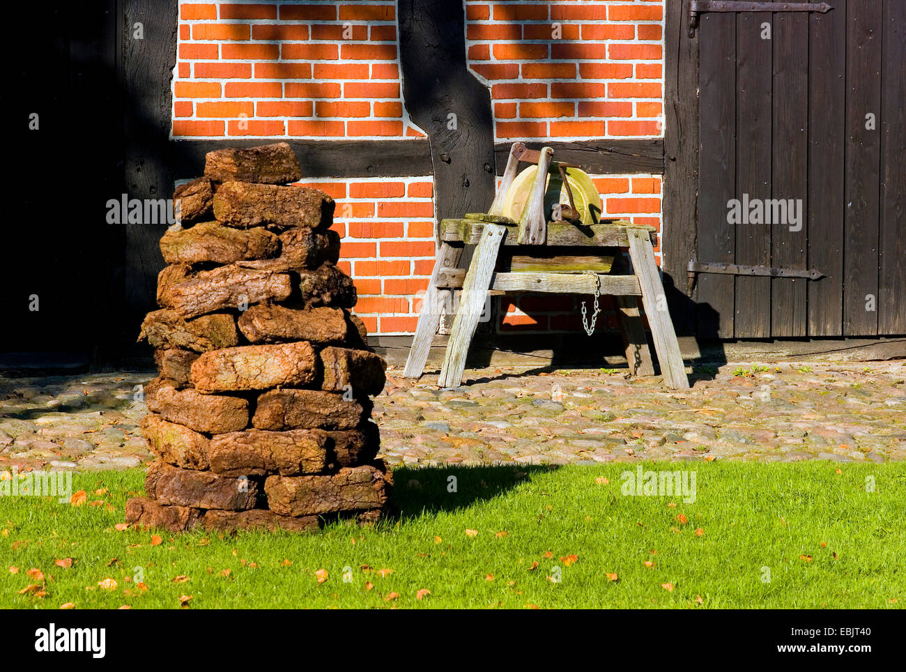 Torf-Stack und Schleifscheibe vor einer Scheune im Freilichtmuseum Osterholz-Scharmbeck, Deutschland, Niedersachsen Stockfoto