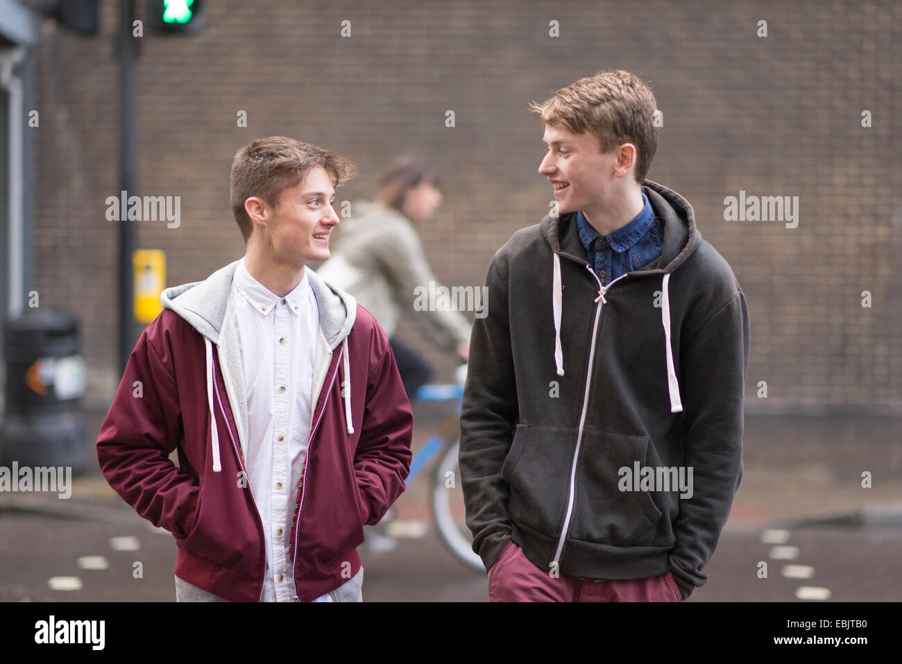 Zwei männliche Freunde, die Straße überqueren Stockfoto