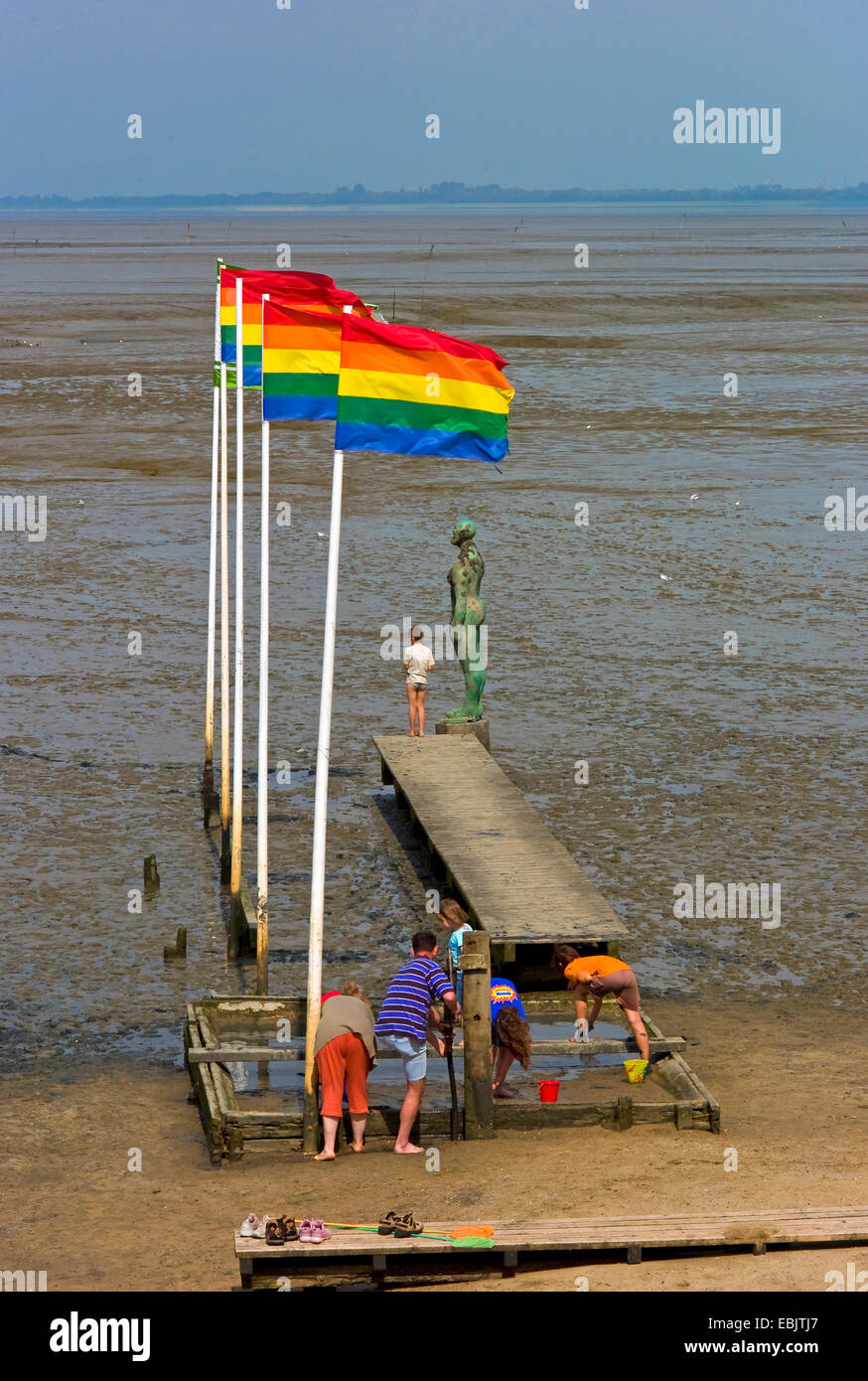 Menschen, bunte Fahnen und Skulptur an einer Fußgängerbrücke im Wattenmeer, Dangast, Friesland, Niedersachsen, Deutschland Stockfoto