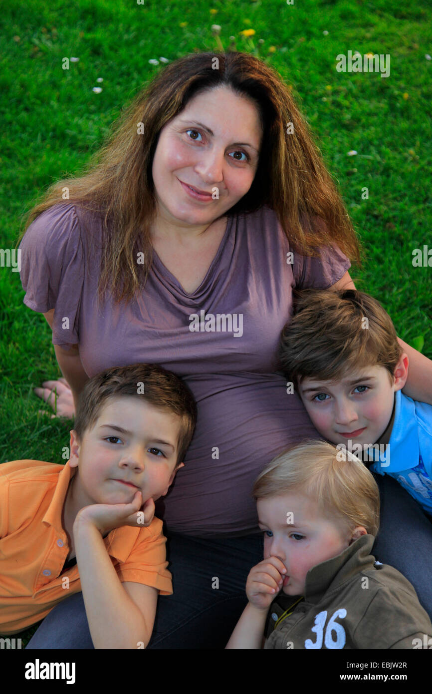 schwangere Mutter mit ihren drei Söhnen Stockfoto
