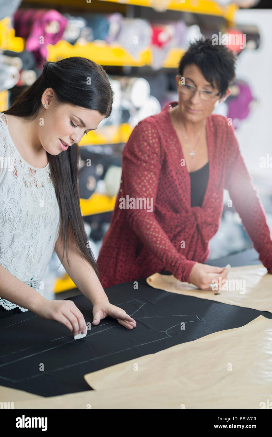 Zwei Näherinnen Kreidung Umriss auf Textil auf Arbeitstisch Stockfoto