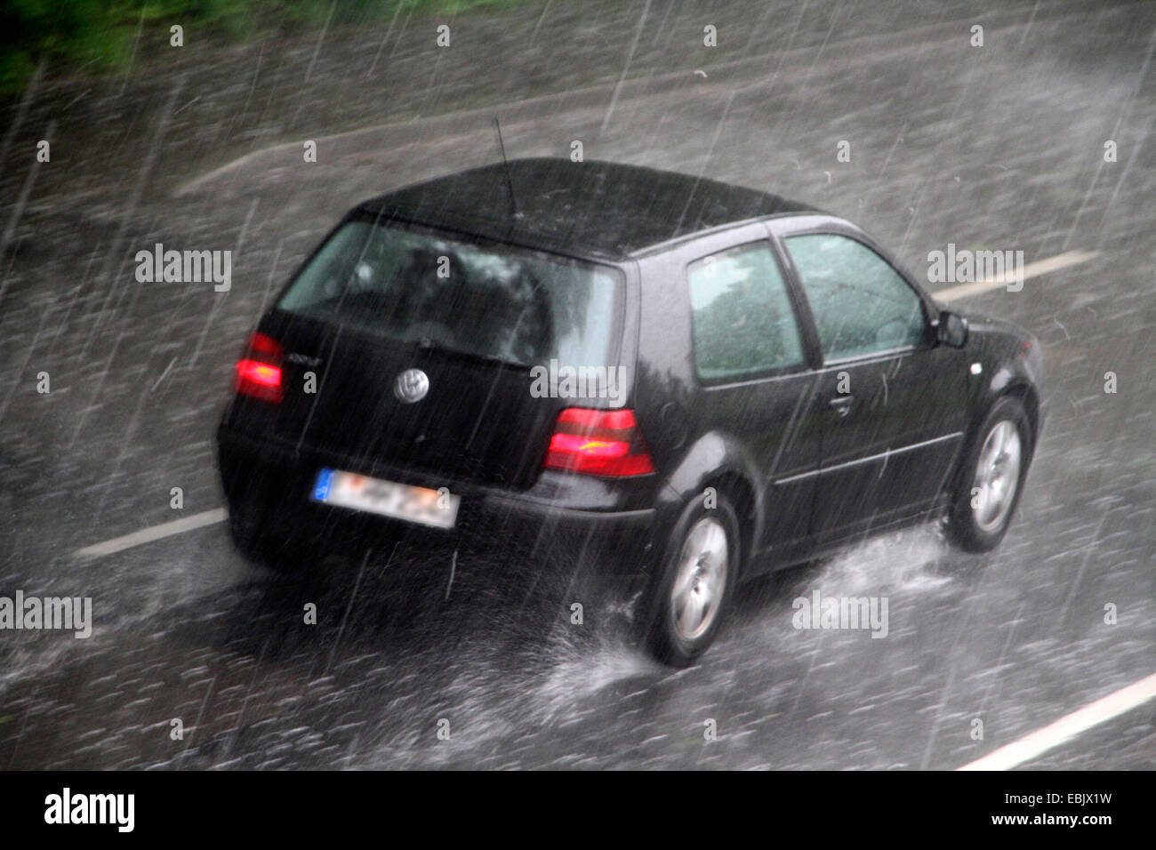 Auto auf der Straße bei starkem Regen, Essen, Ruhrgebiet, Nordrhein Westfalen, Deutschland Stockfoto