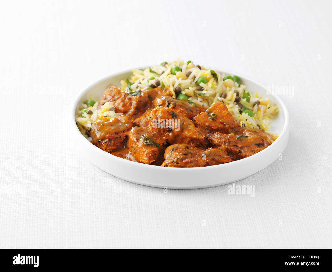 Schüssel mit Chicken Tikka Masala und Erbsen mit gedünstetem Reis Stockfoto