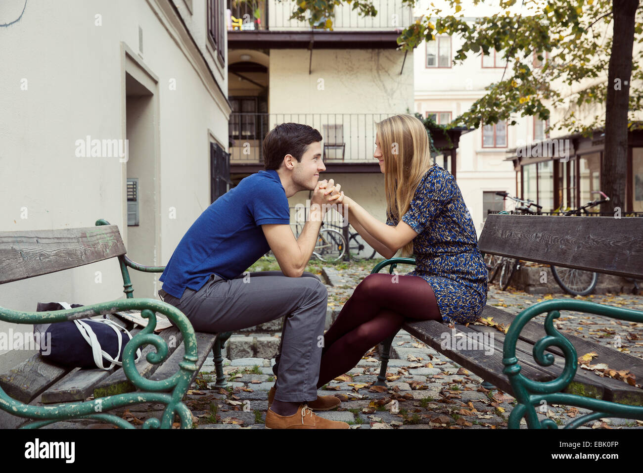 Junges Paar Hand in Hand vom gegenüberliegenden Parkbänke Stockfoto