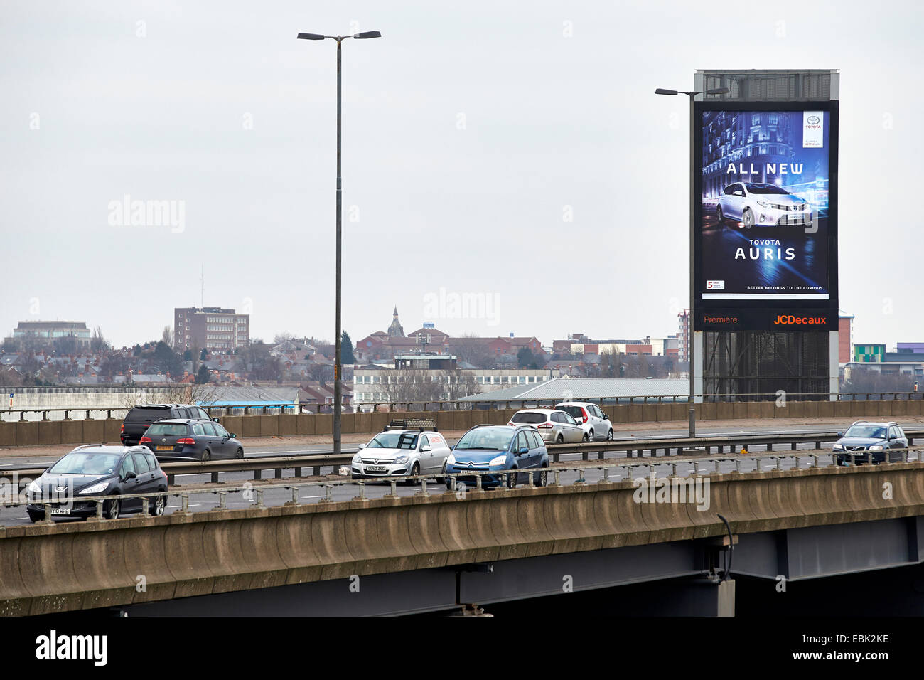 Autos passieren eine beleuchtete am Straßenrand Werbetafel neben der M5 Autobahn, Oldbury, Birmingham. Zwischen den Anschlussstellen 3 und 2. Stockfoto