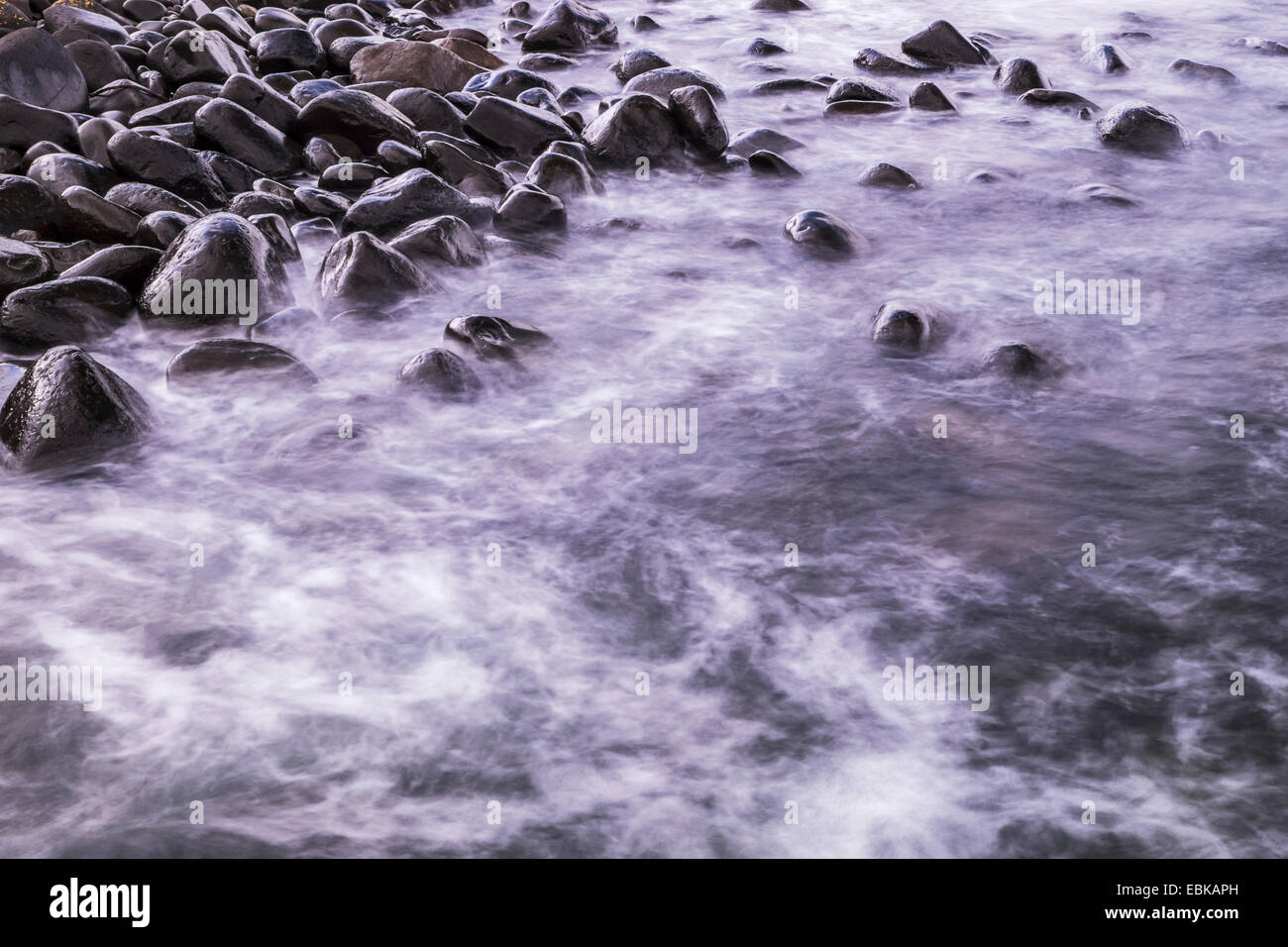 Gezeiten-Wasser waschen, um die Felsen am Dunstanburgh Castle an der Northumbrian Küste, England Stockfoto