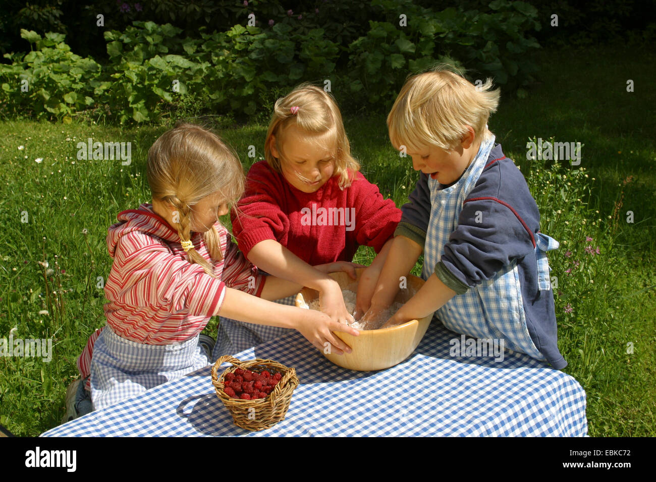 Kinder backen fürchten Obst Brötchen aus Brotteig und Himbeeren, Deutschland Stockfoto
