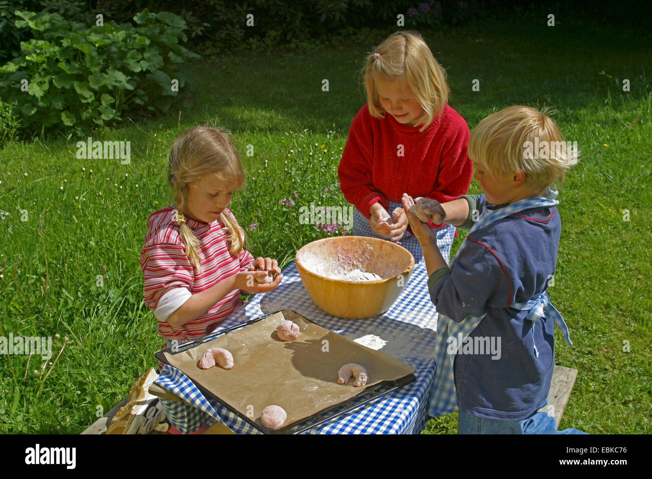 Kinder backen fürchten Obst Brötchen aus Brotteig und Himbeeren, Deutschland Stockfoto