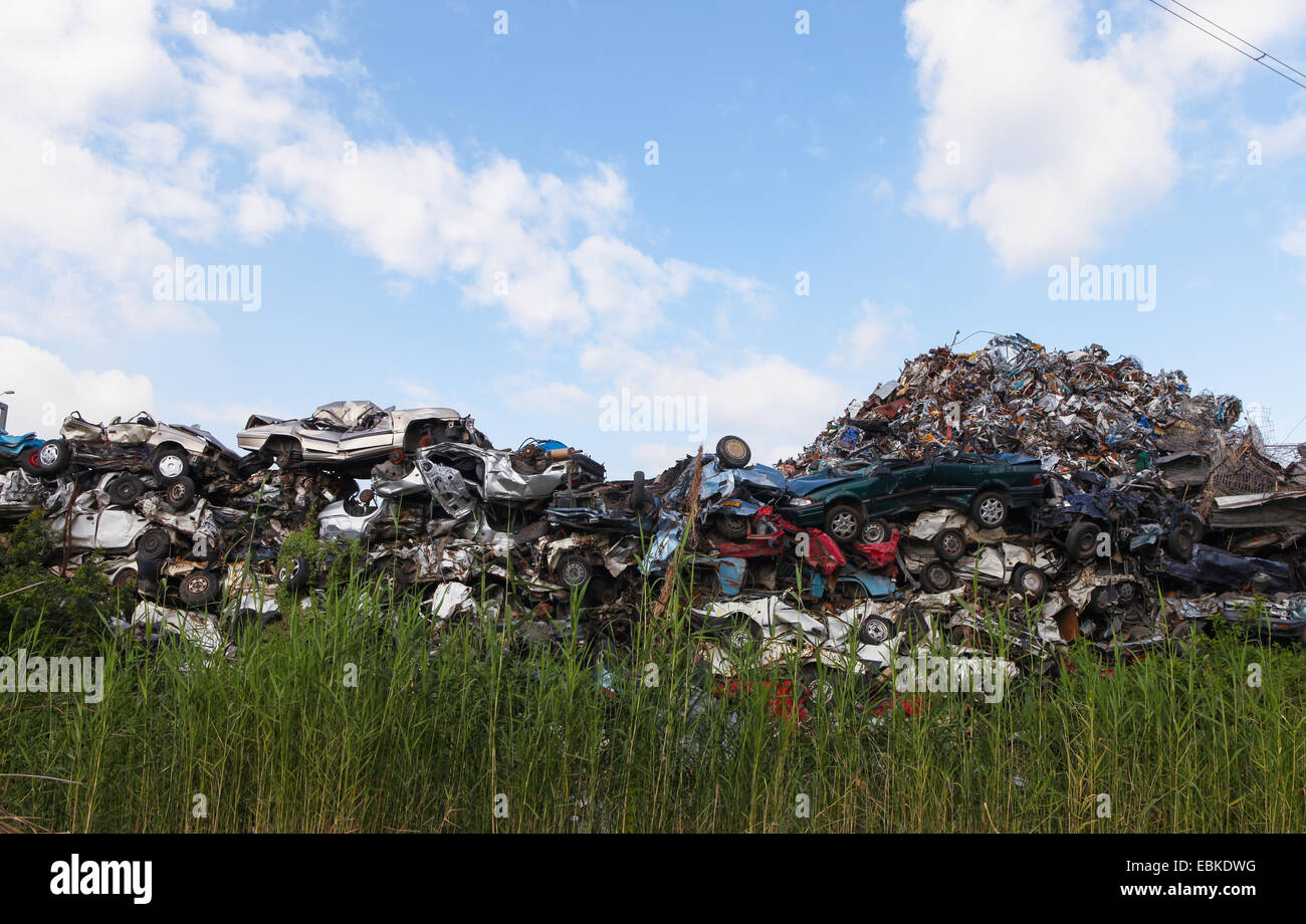 Schrottplatz mit zerquetschten Autos und blauer Himmel Stockfoto