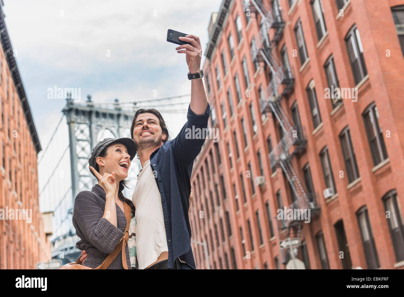 USA, Staat New York, Brooklyn, New York City paar nehmen Selfie auf Street, Brooklyn Bridge im Hintergrund Stockfoto