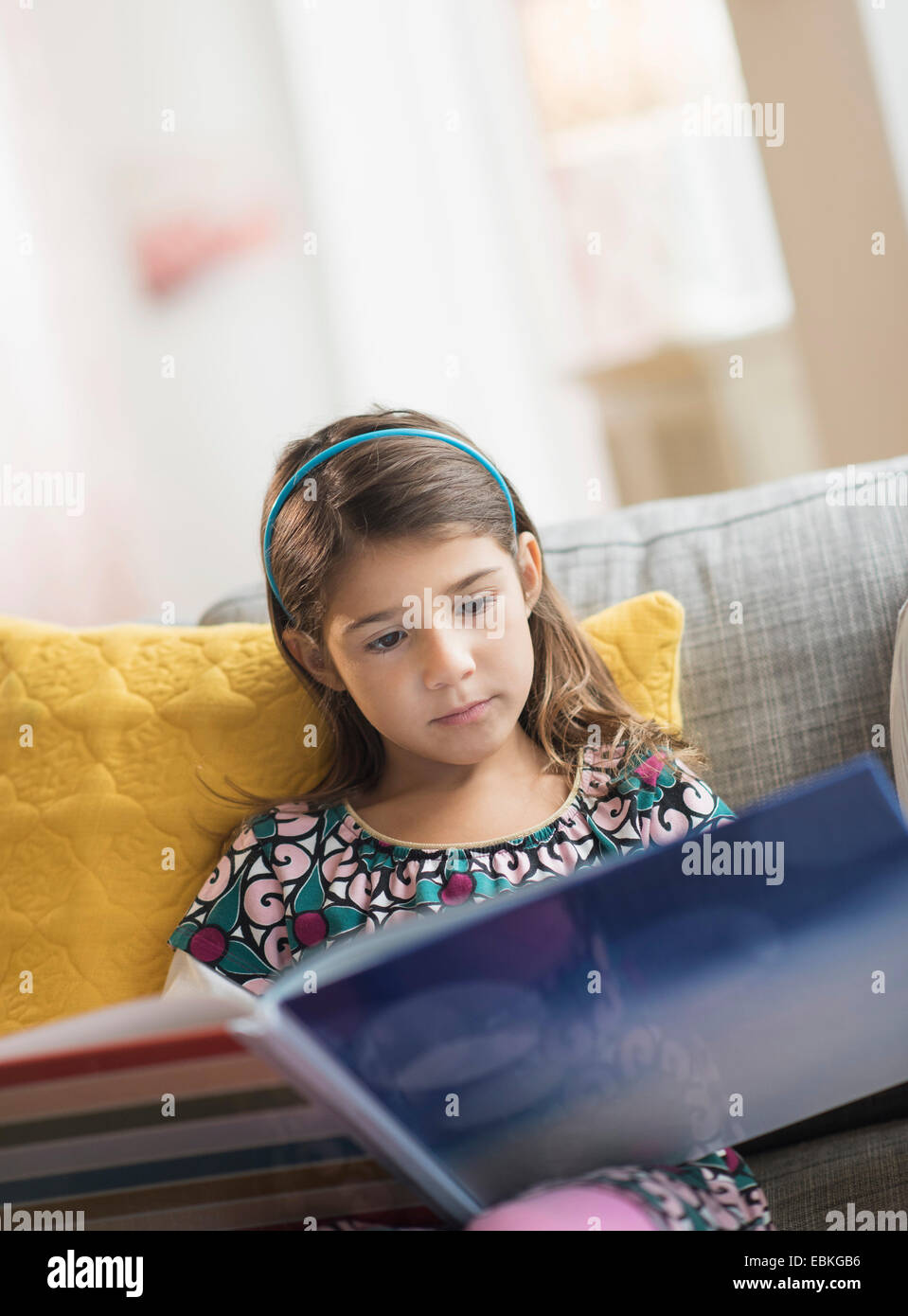 Mädchen (6-7) Lesung buchen zu Hause Stockfoto