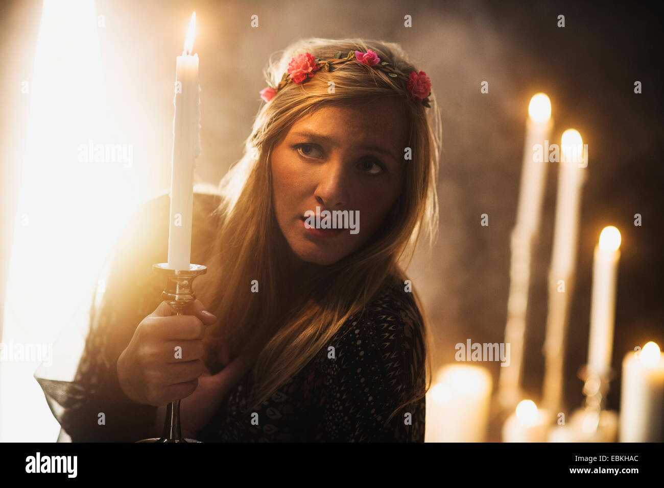 Zauberin Holding Kerze im dunklen Raum Stockfoto