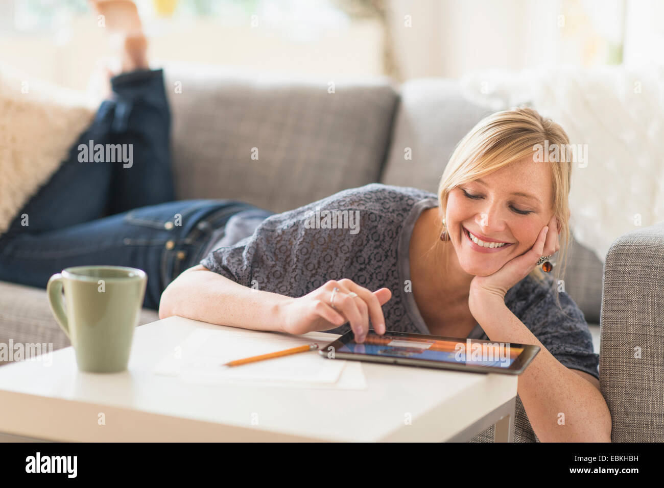 Frau liegend auf Sofa mit TabletPC Stockfoto