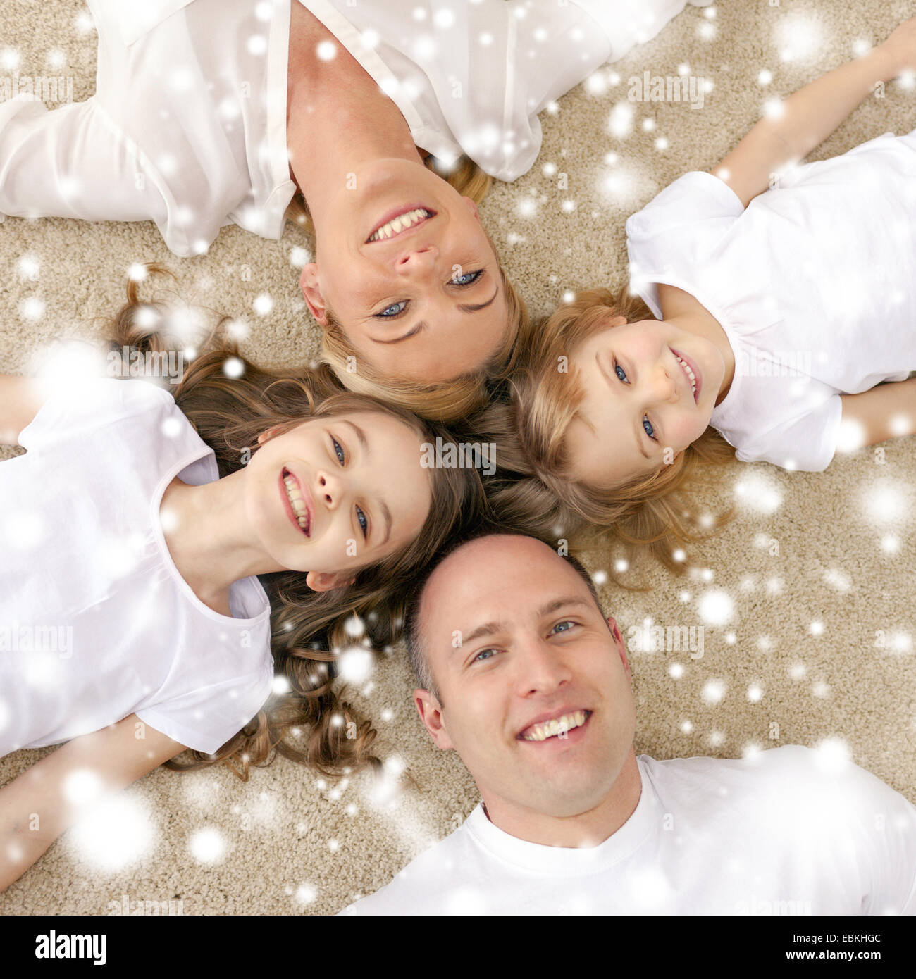 Eltern und zwei Mädchen auf Boden zu Hause Stockfoto