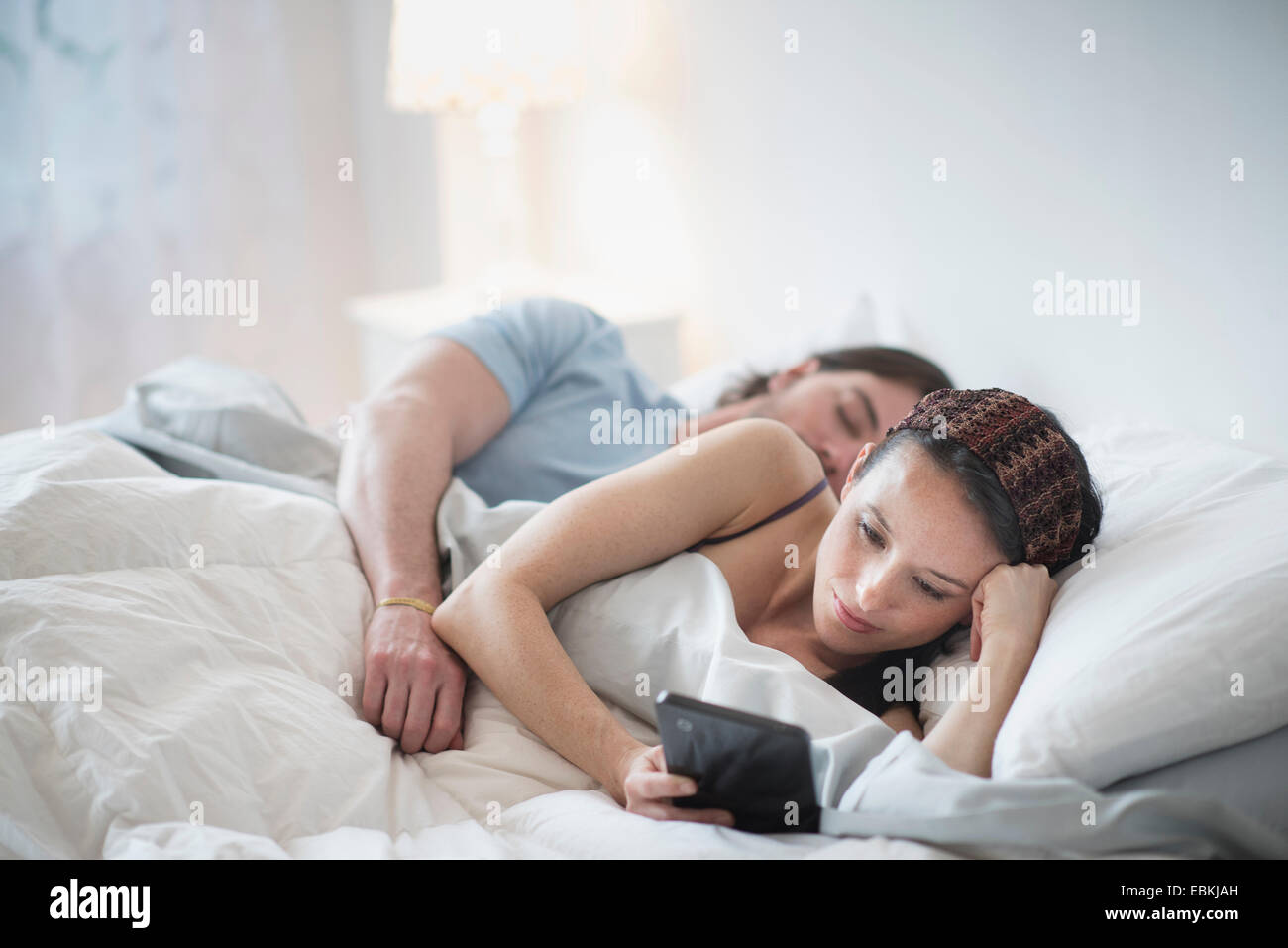 Paar im Bett, schlafen, Mann Frau mit tablet-pc Stockfoto