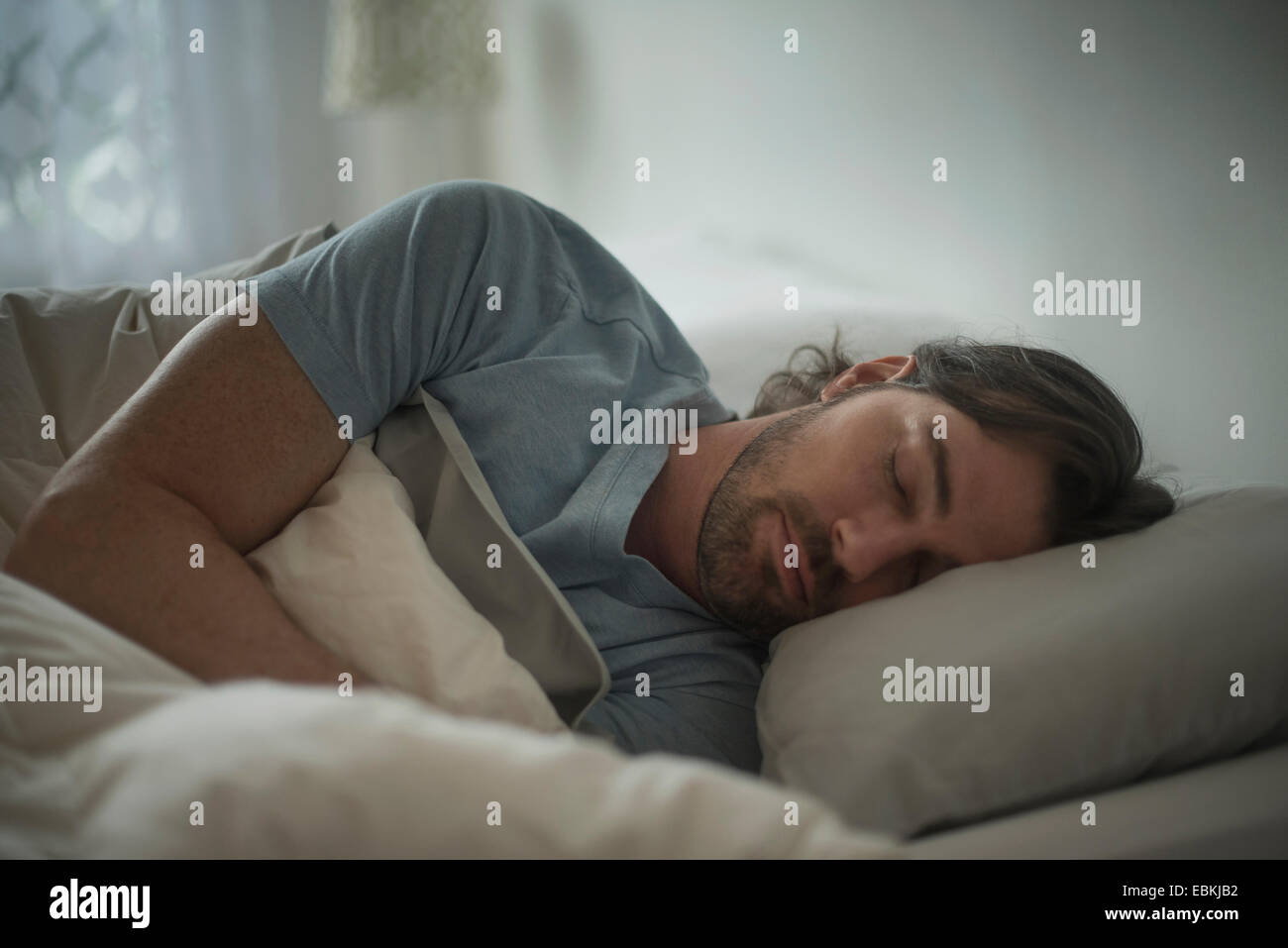 Mann im Bett schlafen Stockfoto