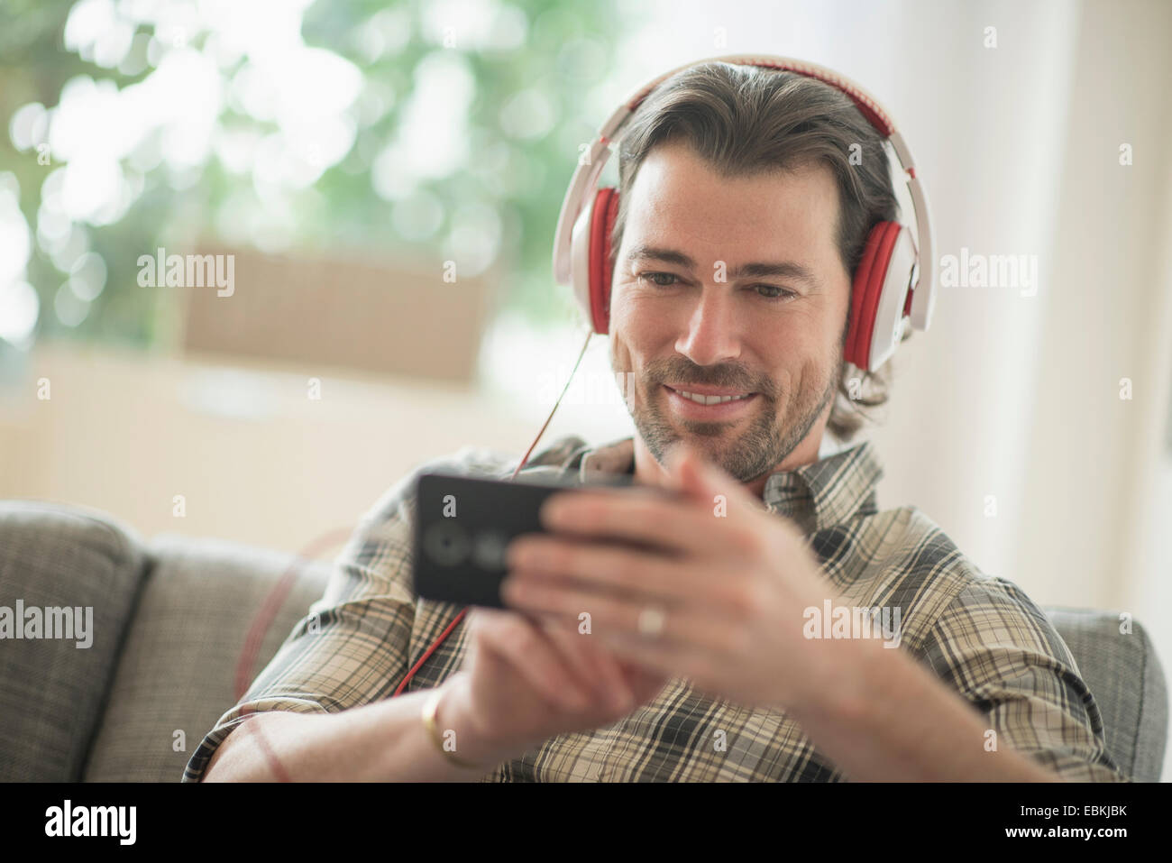 Lächelnder Mann anhören von Musik Stockfoto