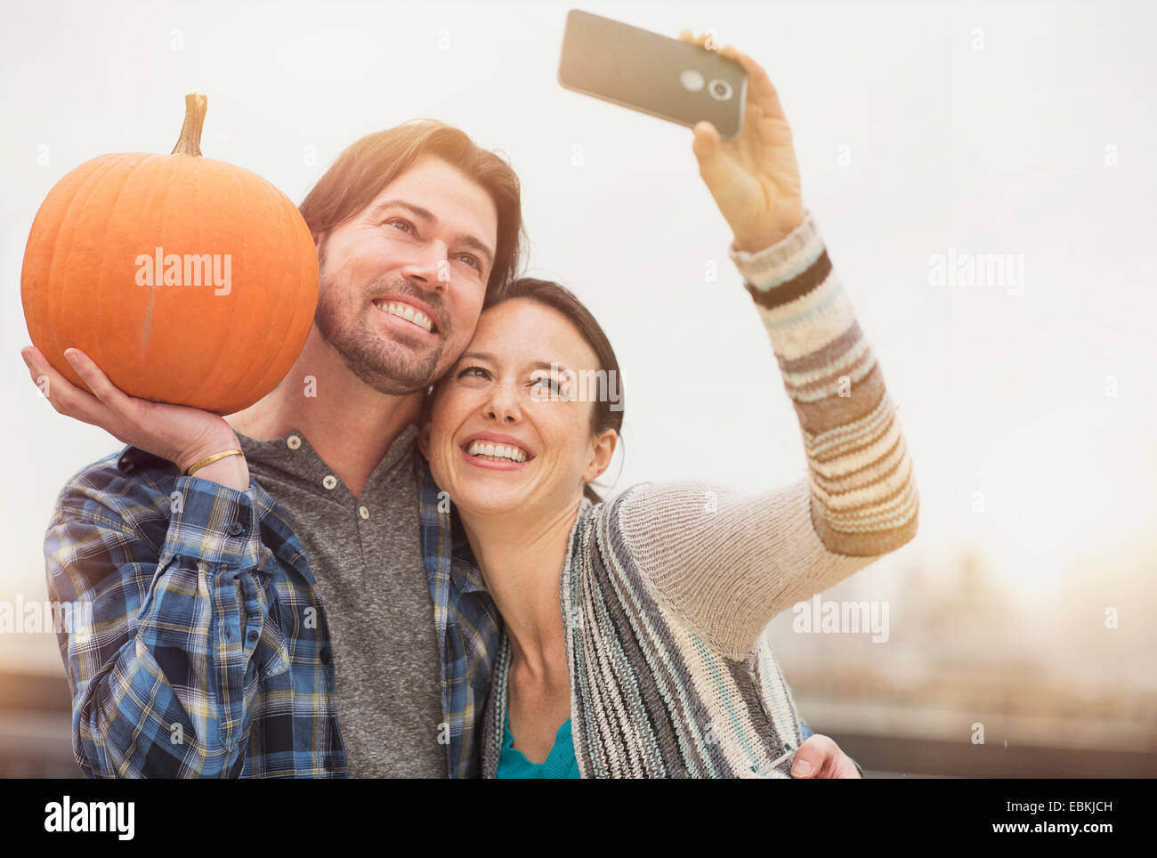 Paar nehmen Selfie mit Handy, Mann mit Kürbis Stockfoto