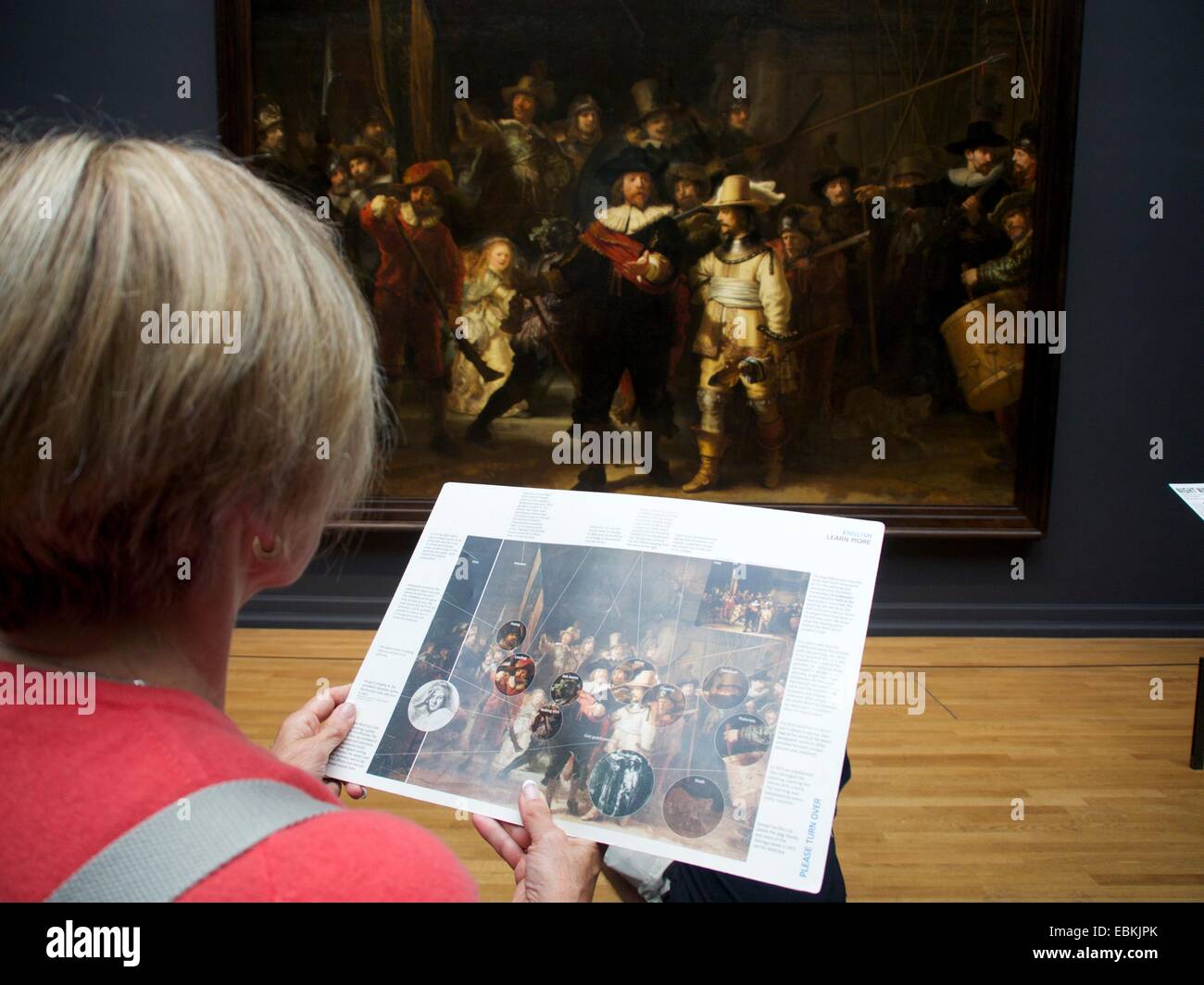 Besucher bewundern Rembrandts Nachtwache im Rijksmuseum in Amsterdam, während sie Details von einem Reiseleiter erfahren. Niederlande Stockfoto