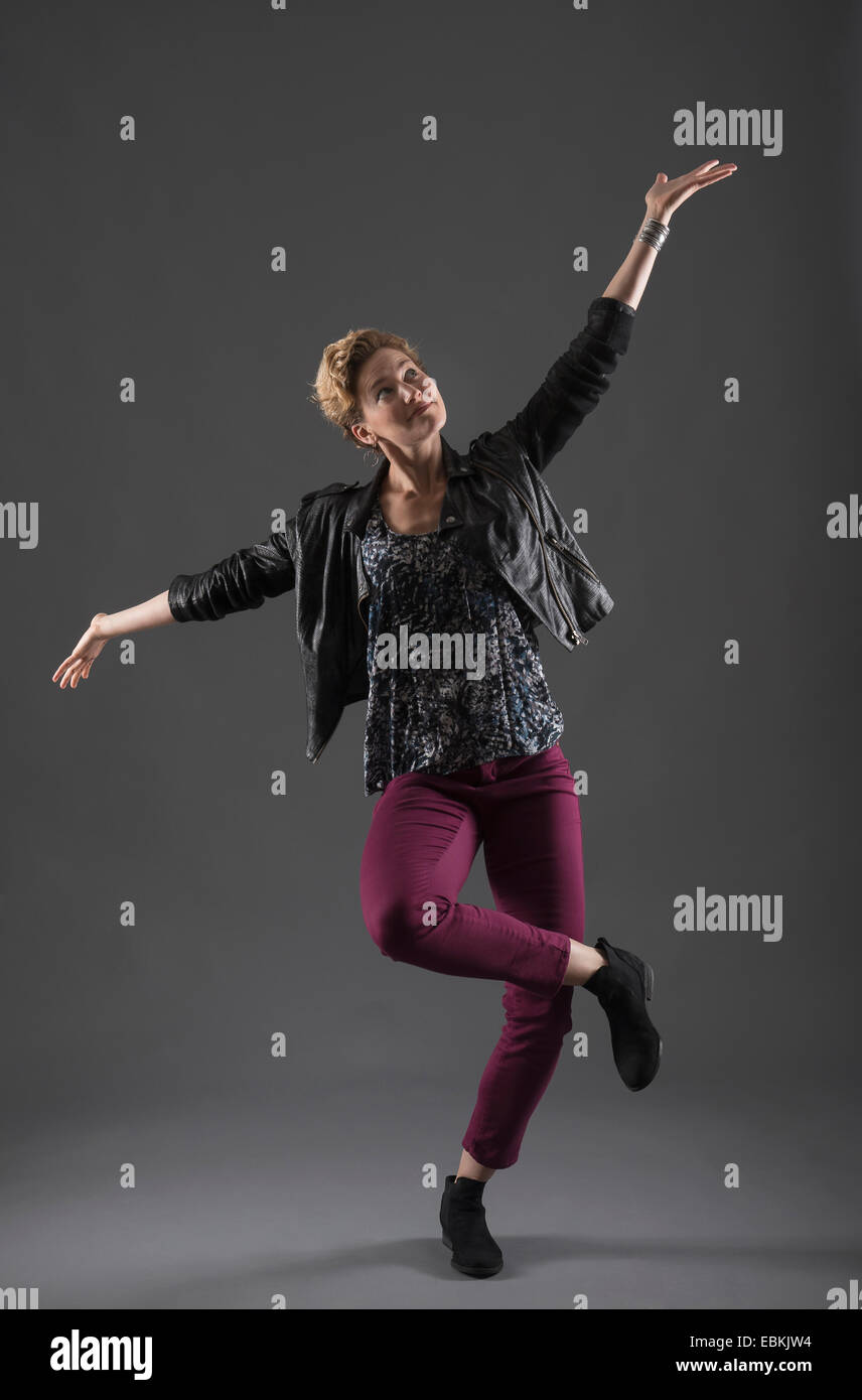 Studioaufnahme der stets gut gelaunte Frau mit erhobenen Armen Stockfoto