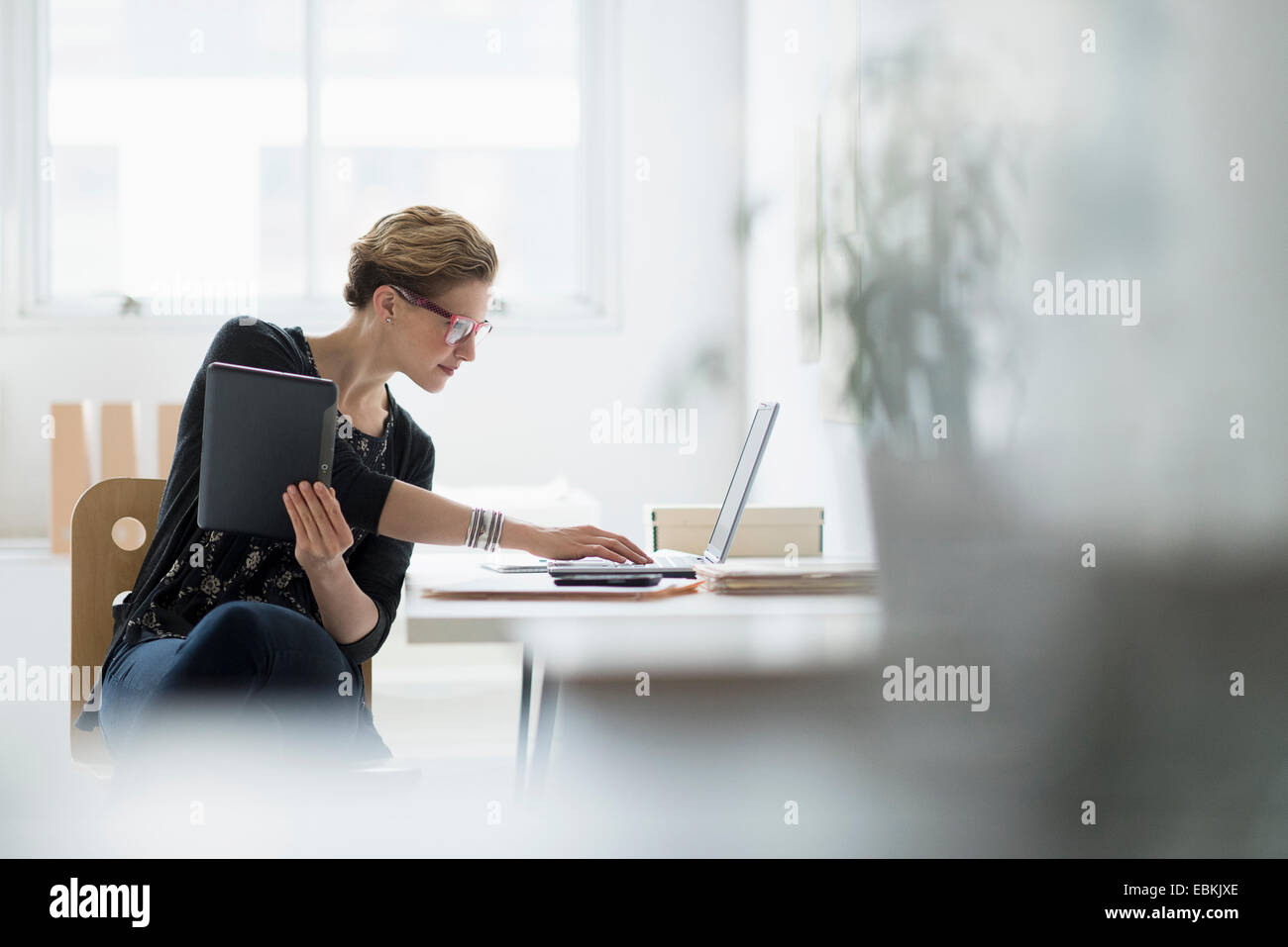Geschäftsfrau mit Laptop im Büro Stockfoto