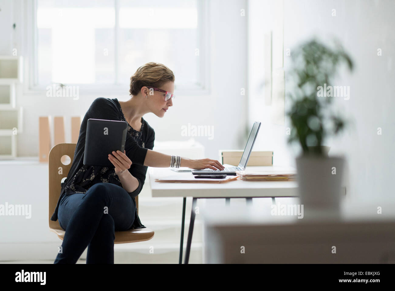 Geschäftsfrau mit Laptop im Büro Stockfoto