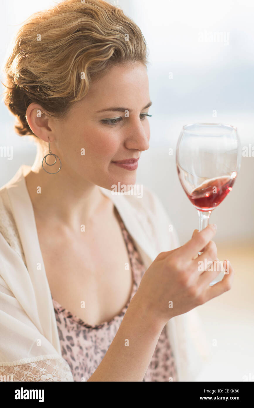 Junge Frau, die wirbelnden Glas Rotwein Stockfoto