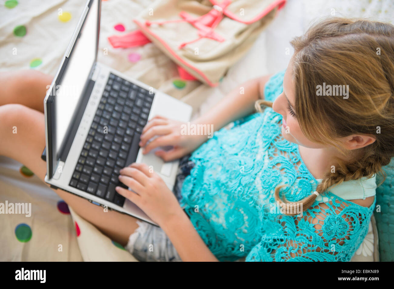 Mädchen (12-13) mit Laptop im Schlafzimmer Stockfoto
