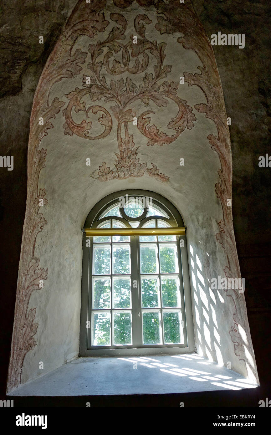 Alten mittelalterliches Fenster im romanischen Baustil mit Malereien verzierte Wand. Stockfoto