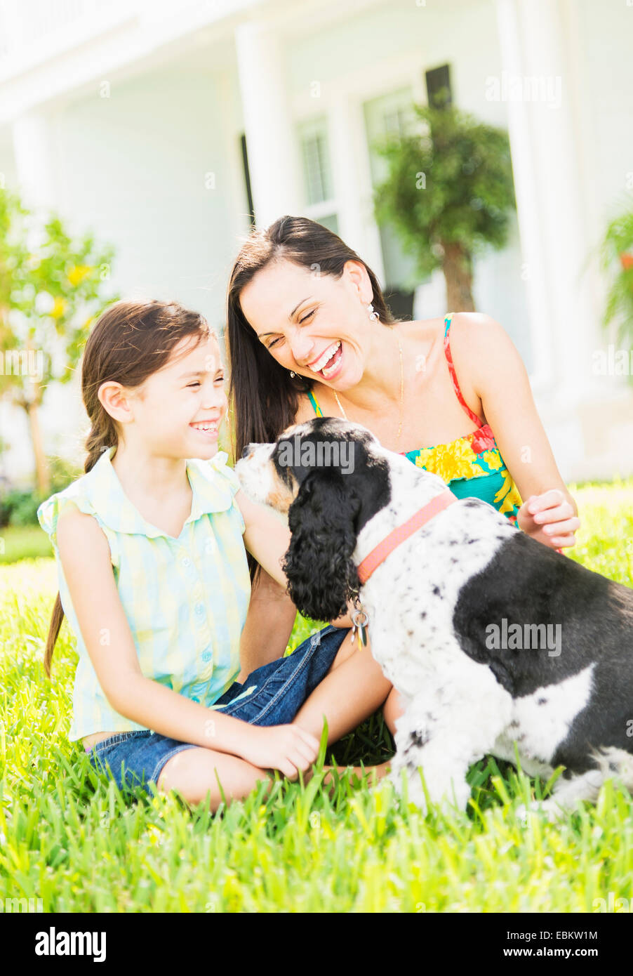 Mädchen (6-7) mit Mutter und Hund im Hinterhof, Jupiter, Florida, USA Stockfoto