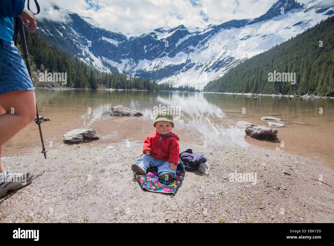 USA, Montana, Glacier Nationalpark, Lawine See, junge (4-5) sitzt am Seeufer Stockfoto