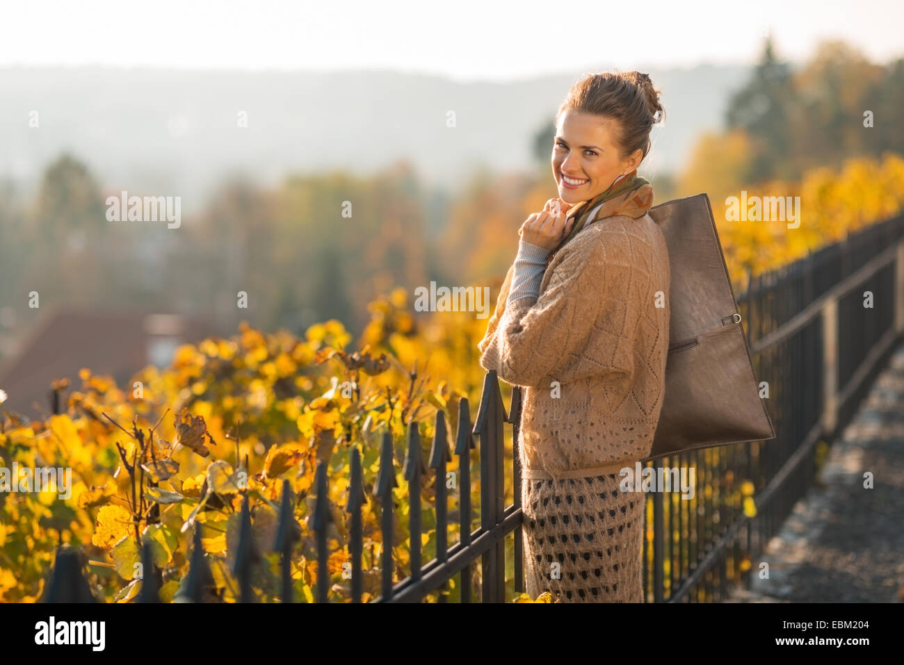 Porträt der glückliche junge Frau, die im Herbst im Freien Stockfoto